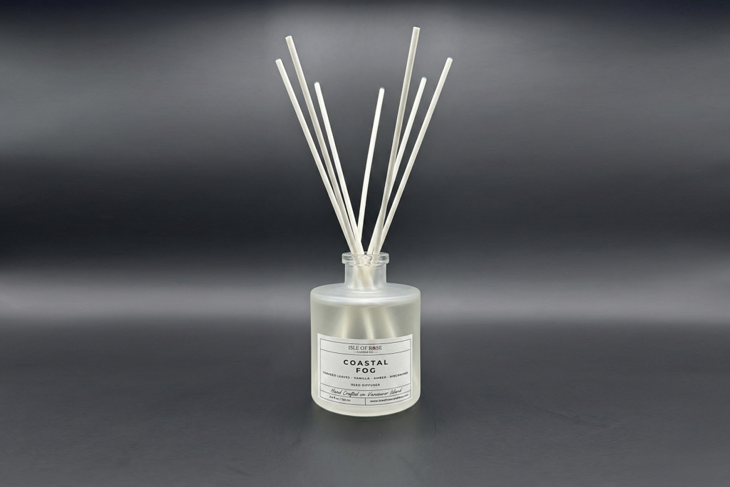 Reed diffuser labeled 'Coastal Fog' on a dark background