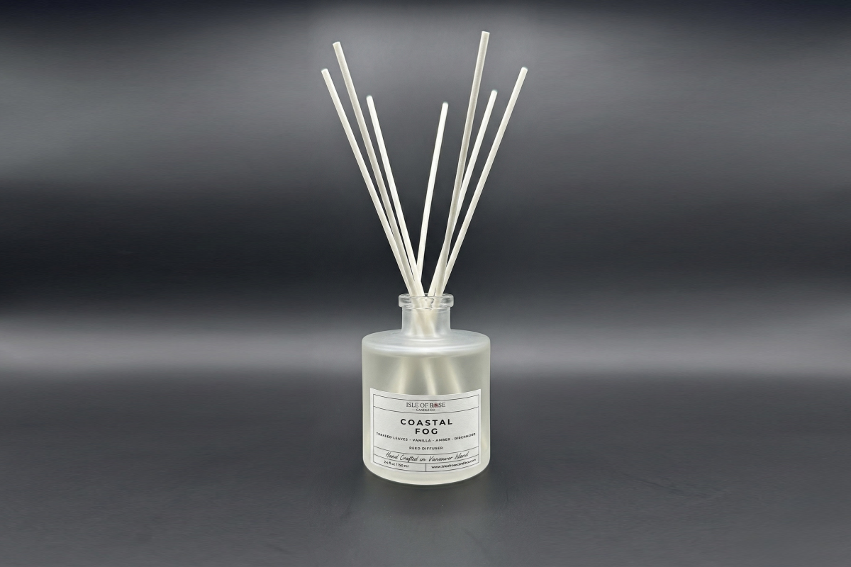 Reed diffuser labeled 'Coastal Fog' on a dark background