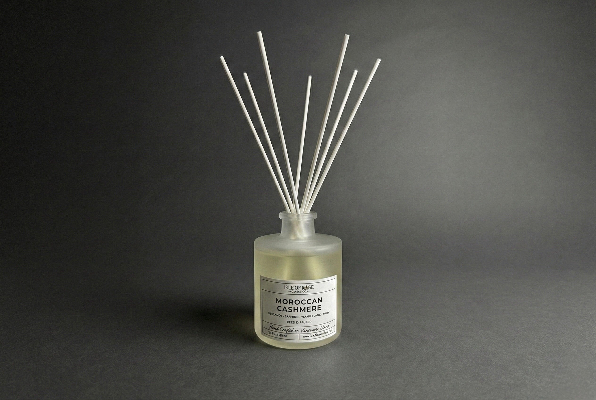 Reed diffuser labeled 'Moroccan Cashmere' on a dark gray background
