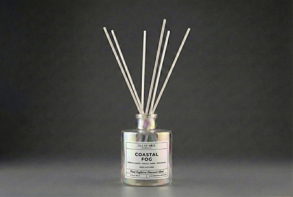 Reed diffuser labeled 'Coastal Fog' on a dark background