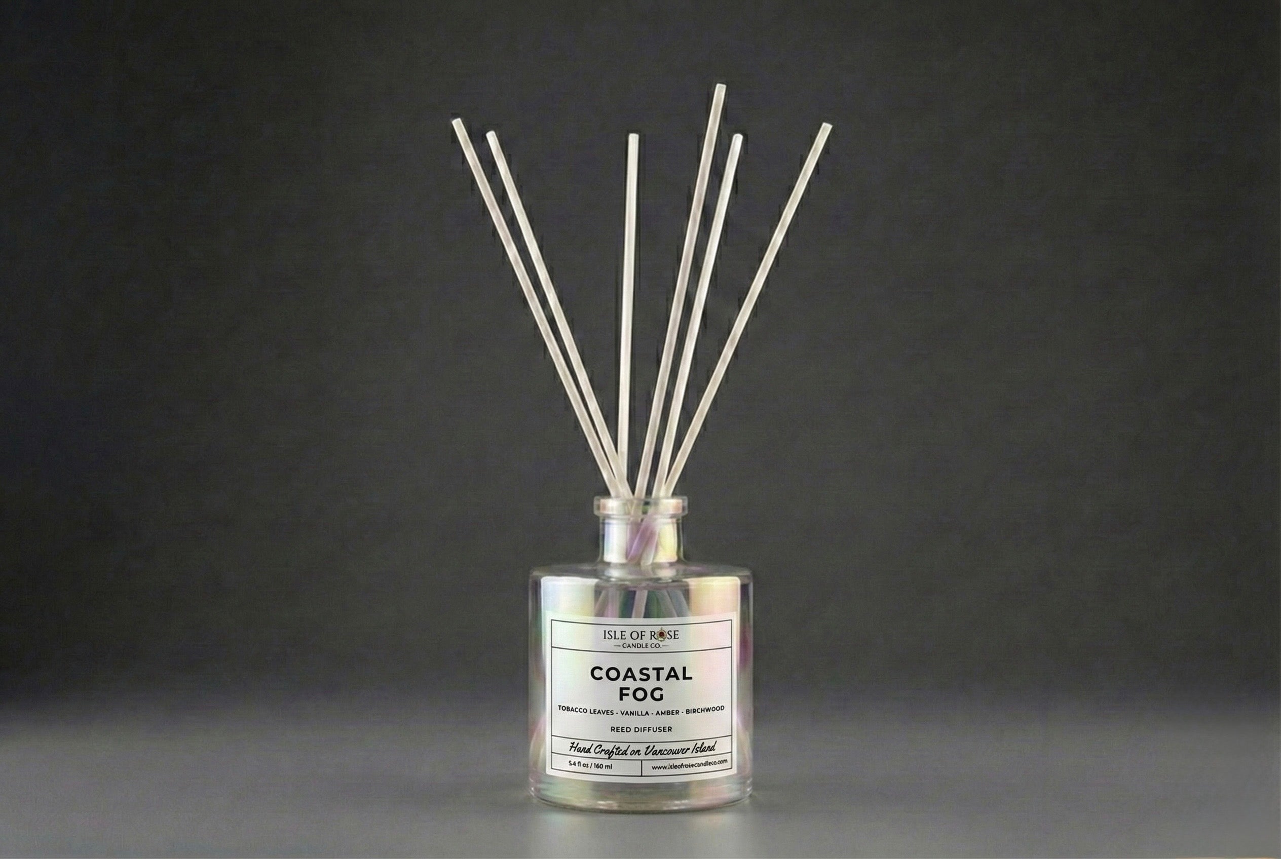 Reed diffuser labeled 'Coastal Fog' on a dark background