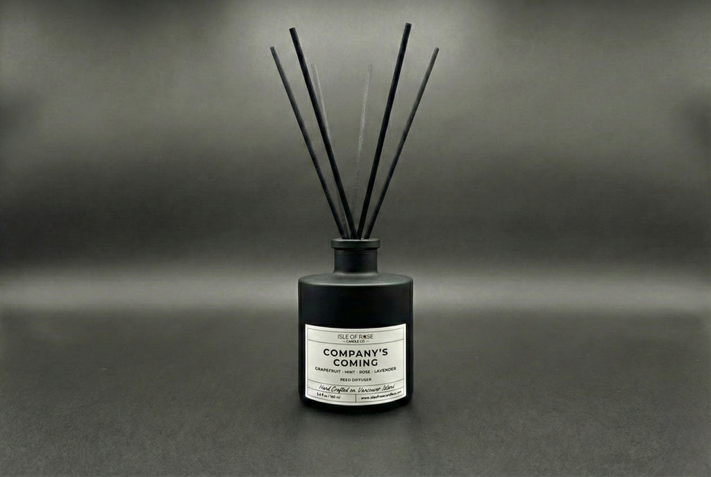 Black diffuser bottle labeled 'Company's Coming' on a dark background