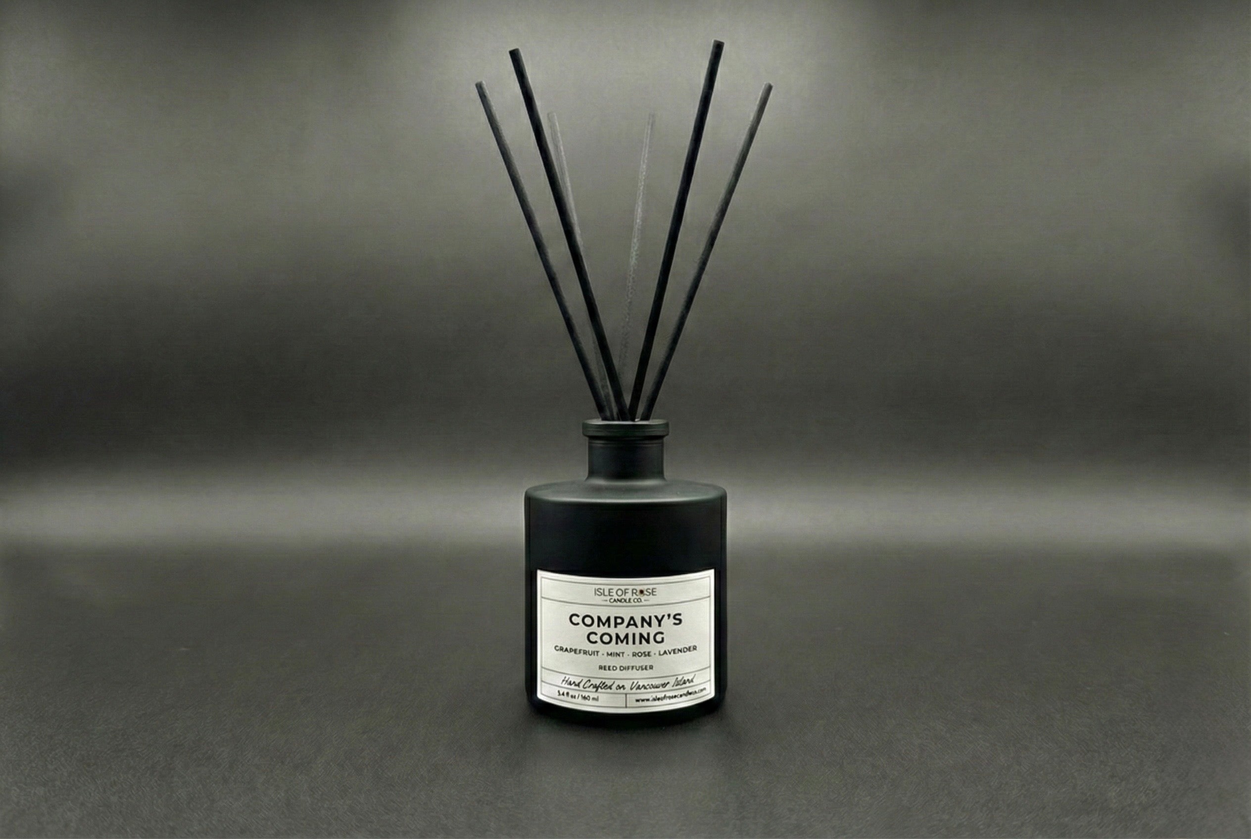 Black diffuser bottle labeled 'Company's Coming' on a dark background