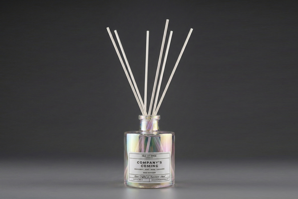 Reed diffuser with labeled bottle on a dark background