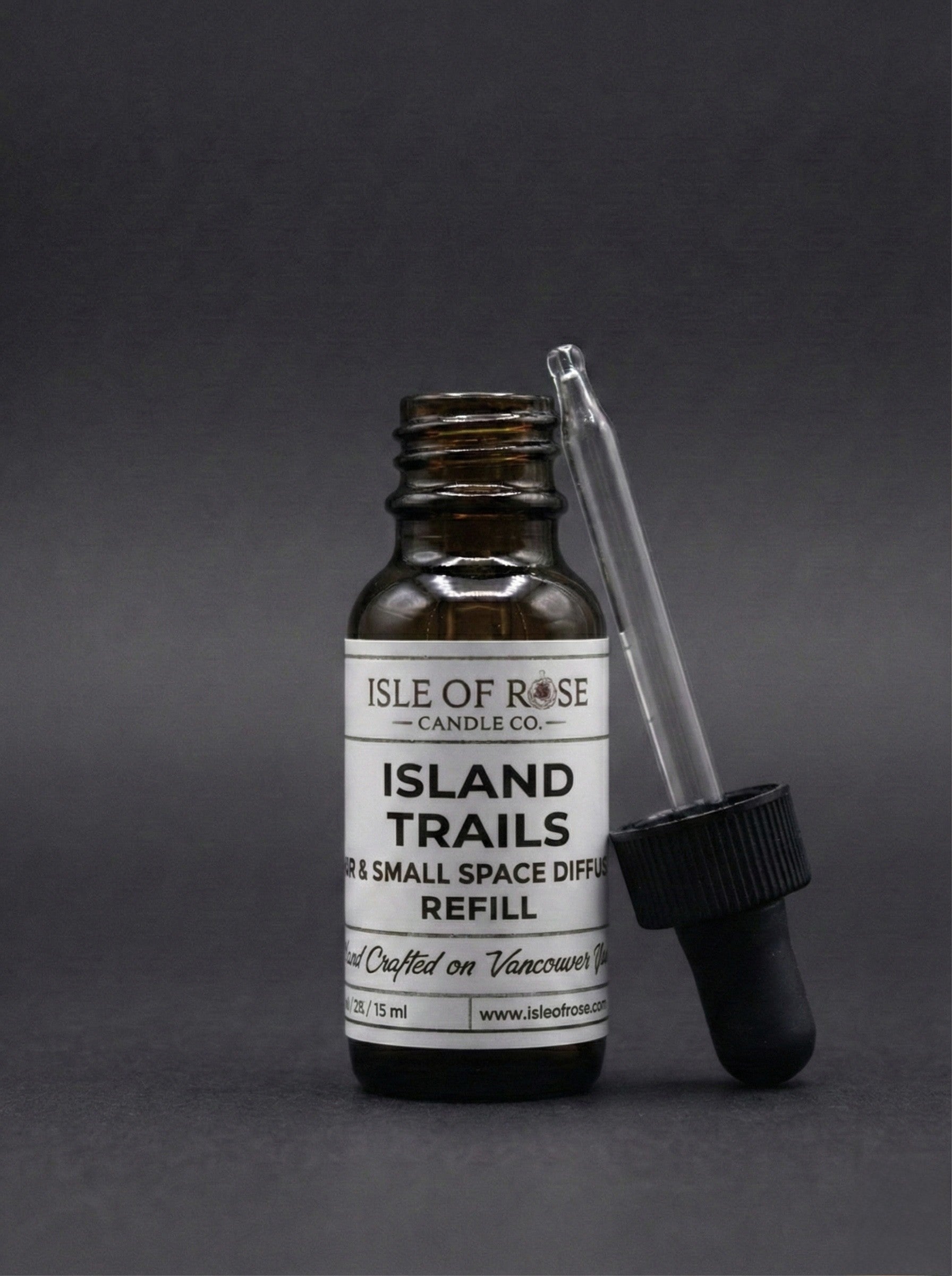 Isle of Rose Candle Co. Island Trails diffuser refill bottle with dropper on a gray background
