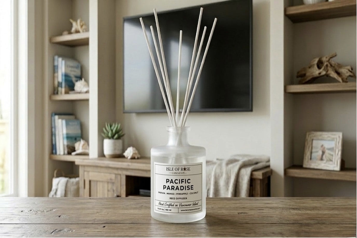 Diffuser bottle labeled 'Escape to Paradise' on a wooden surface with a home interior background.
